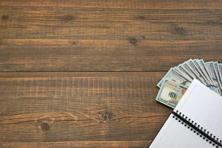 Notepad With American Dollar Cash On The Rough Rustic  Brown Wood Baclground With Copy Space,...