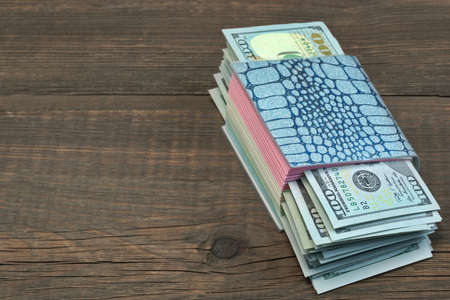 Notebook With Tear-off Sticker Pages And USA Dollar Cash On The Rough Brown Wood Background With...