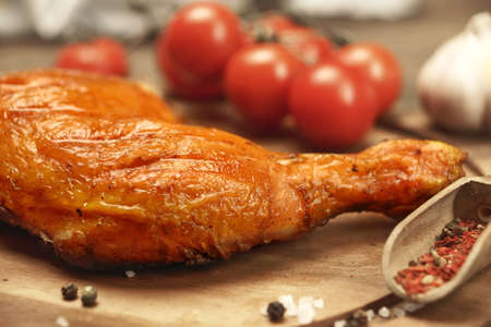Single Grilled BBQ Crispy Chicken Leg Quarter On The Wood Board And Country Table In The Background, Front View, Closeupの写真素材