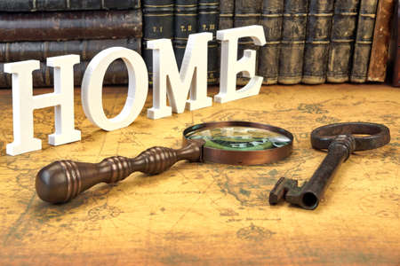 Wood sign home, door key and magnifier on the old mapの写真素材