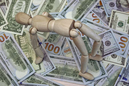 Wooden Human Figurine On The Dollar Cash Background, Top View, Close-Up