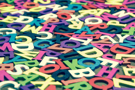 Tonned Random English Wooden Multicolored Letters On  Wood Background, Close Up, Top View, Horizontal Imageの写真素材