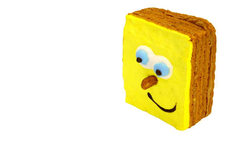 Close-up Of Single Brownie Cake With Human Smiling Yellow Face Isolated On White Backgroundの写真素材