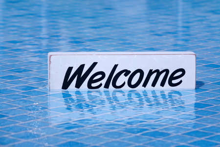Welcome Sign And Empty Swimming Pool Surface In The Background, Pool Party Invitation Conceptの写真素材
