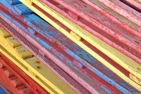 Vintage Old Colorful  Wooden Weathered Sunbeds With Cracked Paint In Stack Background Texture,  Perspective Diagonal View, Close up. Retro Wood Backgroundの写真素材