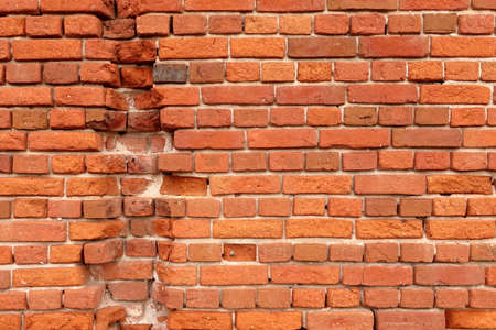 Cracked Dark Red Brick Wall Texture. Old Shabby Worn Red Brickwork With Damaged Surface. Red - Brown...