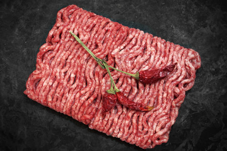 Raw Minced Meat On Black Vintage Background. Top View Of Fresh Ground Beef Isolated On Black...