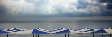 Parasol Top Closeup View On Sea Beach. Seascape With Blue Sky And Claim Sea Water. Beach Umbrellas...