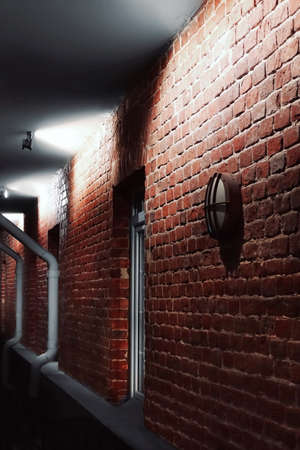 Facade lighting On Brick Wall Of Old House At Night In Perspective Viewの写真素材