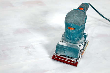 Electrical Sanding Machine On The Paint Wooden White Floor With Sandpaperの写真素材