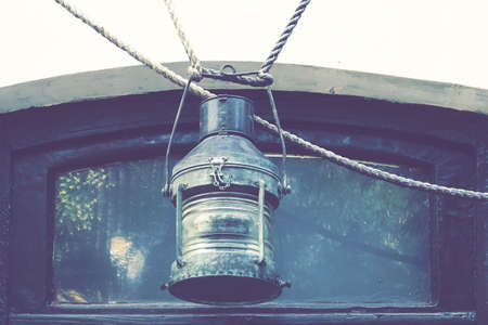 Old Copper Anchor Nautical Oil Vintage Lantern Or Retro Lamp Hanging On Rope.の写真素材
