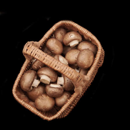 Brown Champignon Mushrooms In Wicker Basket, Isolated On Black Background, Top View. Champignon Brown Mushrooms Overhead View. Fresh Uncooked Mushrooms On Black Background. Cream Soup Ingredients.の写真素材