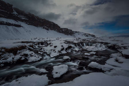 Frozen waterfall in a winter day in Icelandの写真素材