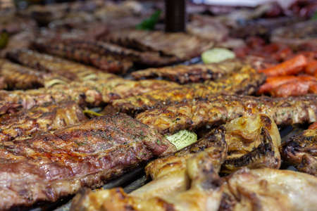 Pork ribs and sausages grilled in a barbecue