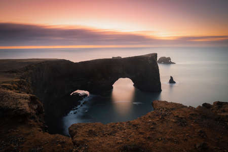 Dyrholaey lighthouse over black sand beach in Iceland