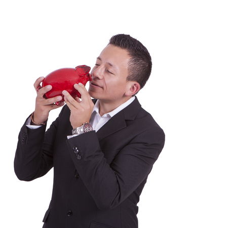Image of a handsome young mixed race businessman kissing his piggy bankの写真素材