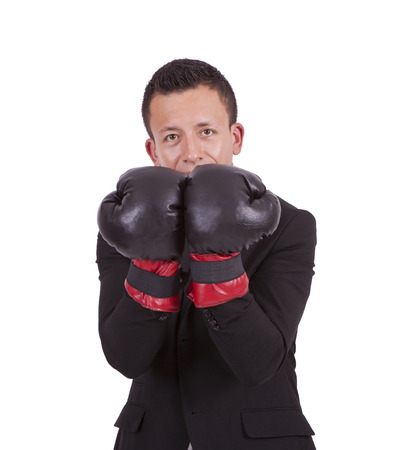 Portrait of a young businessman wearing boxing gloves posing against whiteの写真素材