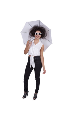 Image of an attractive young female posing with umbrella and sunglassesの写真素材