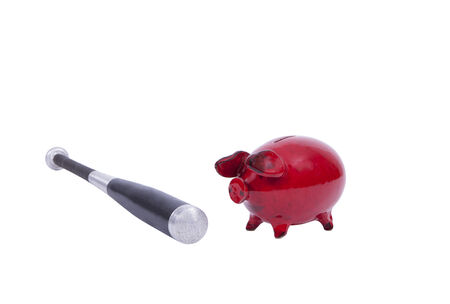 Red piggy bank with baseball bat isolated over white backgroundの写真素材