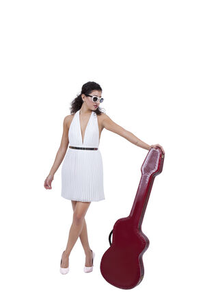 Attractive young female wearing sunglasses posing with guitarの写真素材