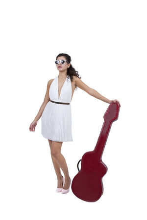 Attractive female wearing sunglasses posing with guitarの写真素材