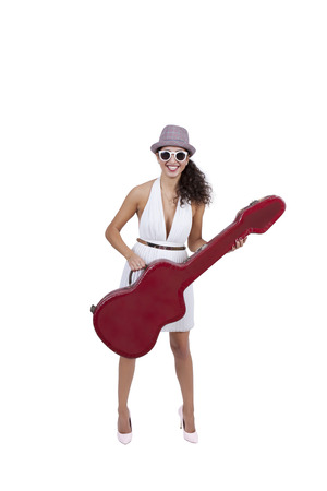 Happy young female wearing sunglasses posing with guitarの写真素材