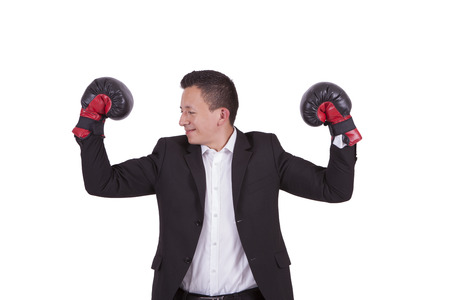 Young businessman with boxing gloves flexing bicepsの写真素材