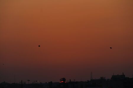 Bright orange sunset over the city in the evening.の写真素材