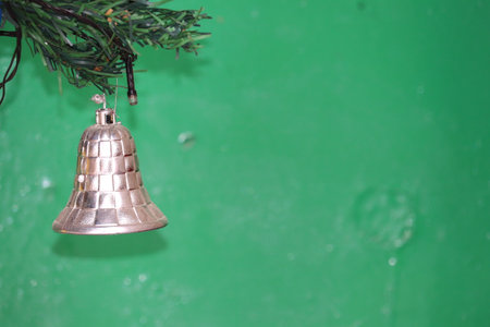 christmas tree and bell on green background with space for text.の写真素材