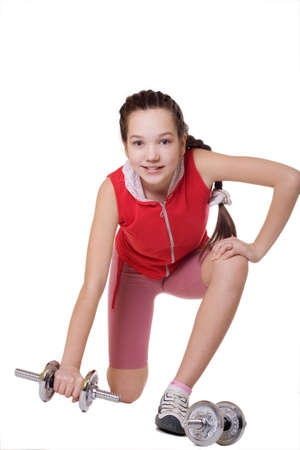a beautiful girl goes in for sports, it is isolated on a white background. in hands for it dumb-bellsの写真素材