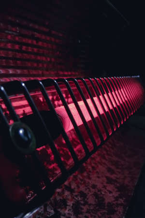 A red metal fence in a dark room, close-up.の写真素材