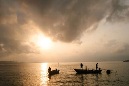 Fisherman busy fishing from a boat on a beautiful morning の写真素材