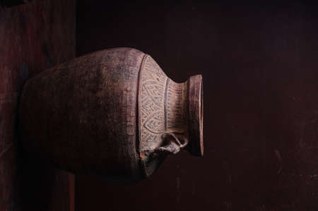 Earthenware jug standing on dark roomの写真素材