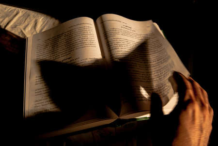 Open book in hands on black backgroundのeditorial素材