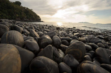 An image of stones on the beach with sunsetの写真素材
