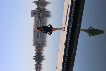 Photo of a Beautiful white girl in a beautiful dress standing in front of a lake