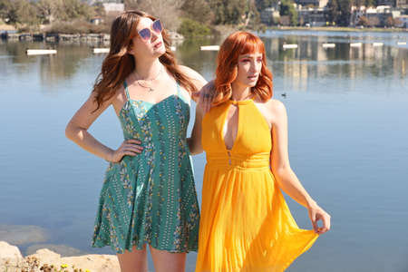 Photo of two white girls in beautiful dresses in front of a lakeの写真素材