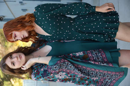 Photo of two white girls in beautiful dresses near a building