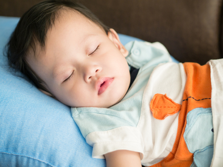 Asian toddler sleeping in house.