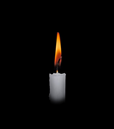 One light candle burning brightly in the black backgroundの写真素材