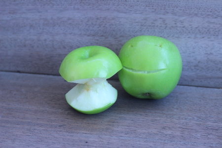 Apple carved with a knife, a beautiful smile on a gray backgroundの写真素材