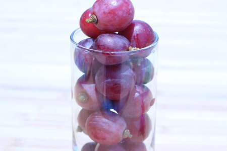 Grapes in a glass placed on a brown backgroundの写真素材