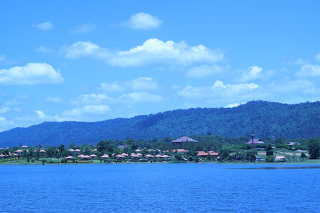 The reservoir has a beautiful background of mountains and skyの写真素材