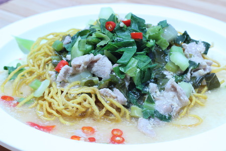 Kale noodles topped with pork and red pepperの写真素材