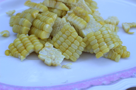 Boiled sweet corn eaten also placed on brown backgroundの写真素材