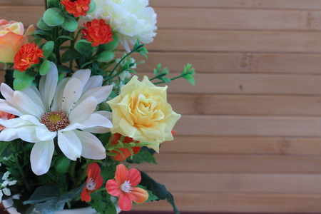 Beautiful flowers in a vase on a wooden brown backgroundの写真素材
