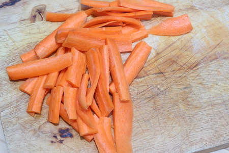 Sliced ââcarrots, onion and coriander leaves on brown butcherの写真素材