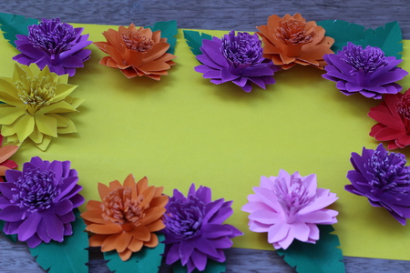 Many colorful paper flowers on a background with a smooth surfaceの写真素材