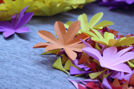 Many colorful paper flowers on a background with a smooth surfaceの写真素材