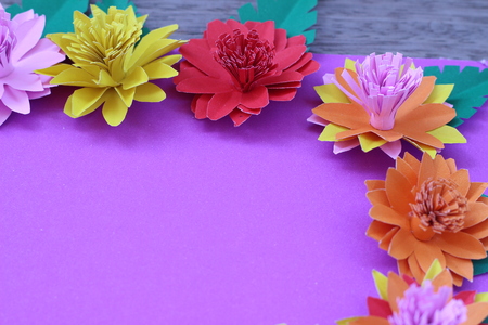 Many colorful paper flowers on a background with a smooth surfaceの写真素材